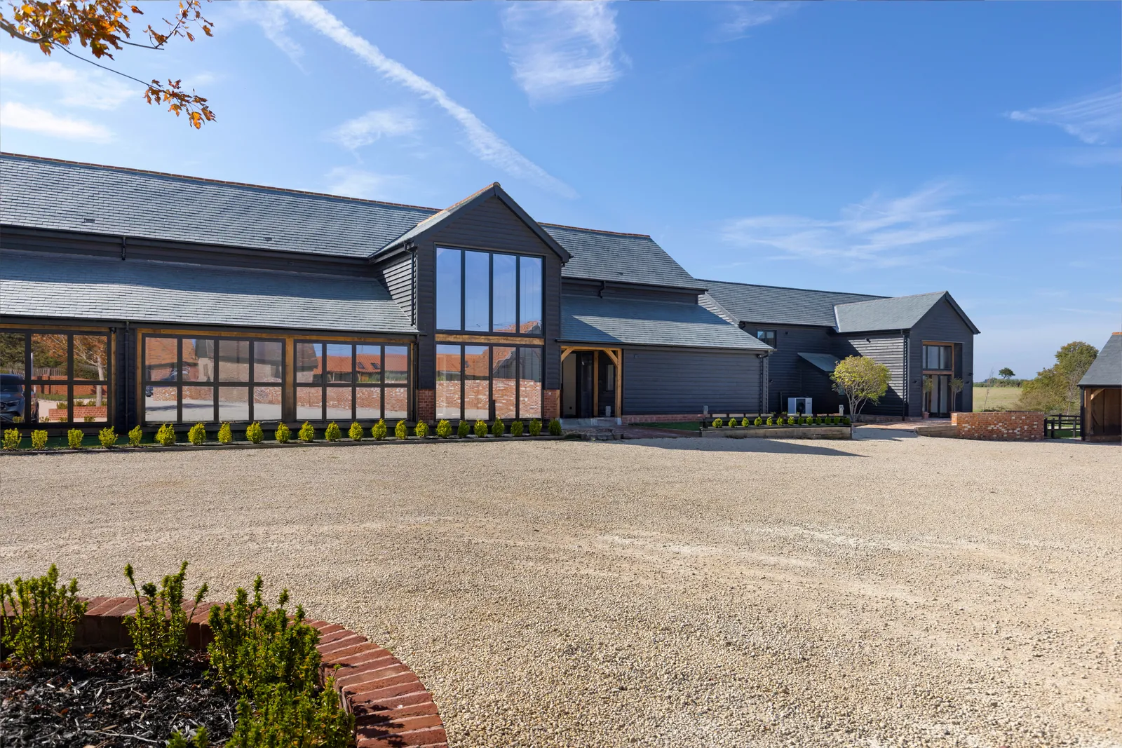 Completed Blythcarr barn conversion: black weatherboard, glazed gables and slate roof